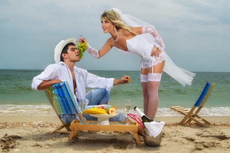 Sexy bride feeding her groom with grapesの写真素材