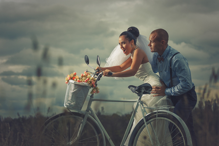 Vintage wedding. Groom and bride on a bicycleの写真素材