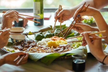 hands of people feasting on Vietnamese foodの写真素材