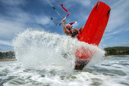 Santa Claus professional kitesurfer rides sea waves and flying over waterの写真素材