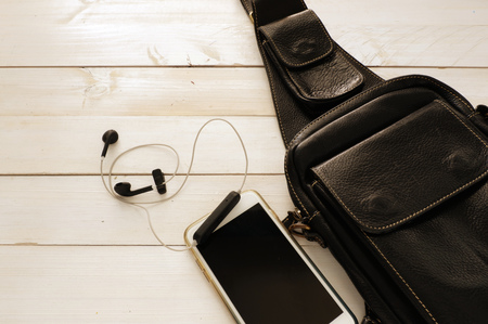 Travel leather black bag and set of smart phone on white  wooden table  ,top view for copy space and concept for travelの写真素材