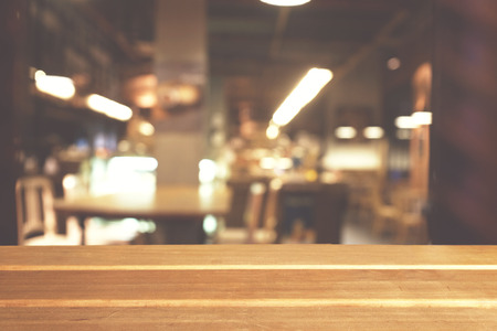Wooden board empty table top on of blurred background. Perspective brown wood table over blur in coffee shop background - can be used mock up for montage products display or design key visual layout.の写真素材