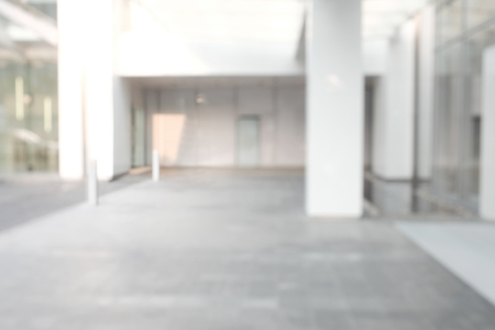Business building blur background office lobby hall interior empty indoor room with blurry light from glass wall window.の写真素材