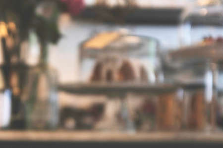 Blurred background image of modern coffee shop. abstract blur background with people in cafe. warm color tone styleの写真素材