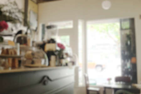 Blurred background image of modern coffee shop. abstract blur background with people in cafe. warm color tone styleの写真素材