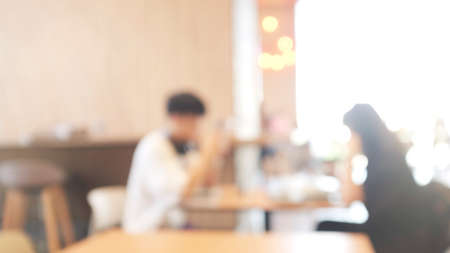 Blurred background image of modern coffee shop. abstract blur background with people in cafe. warm color tone styleの写真素材