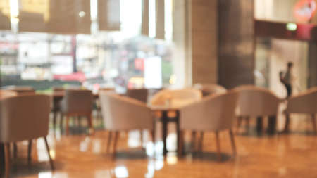 Blurred background image of modern coffee shop. abstract blur background with people in cafe. warm...