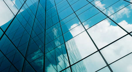 business building in city with mirror windows with reflections of blue sky.