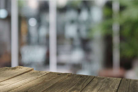 Top wood table Blur coffee shop or cafe restaurant with abstract bokeh light image background....