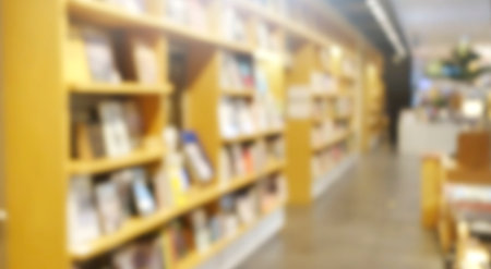 Blur background of book shelf store decorated with wood and warm light.の写真素材