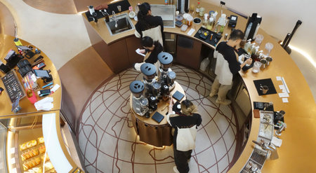 High angle view of barista in cafe. Young asian barista at cafeteria. Barista making a cup coffeeの写真素材