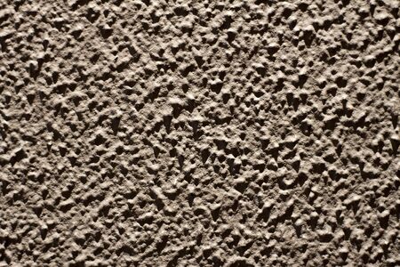 A gray wall that looks like the surface of the moon.