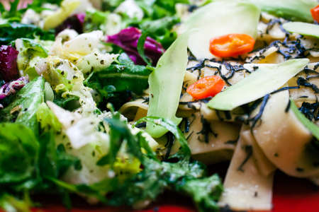 Delicious portion of tagiatelle pasta with hot chilli peppers sprinkled with black truffle cheese. Served with a salad of many varieties of lettuce, arugula and feta cheese in a sauce with Italian spiの写真素材