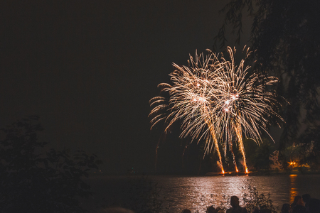 Fireworks explode from the margin of a riverの写真素材