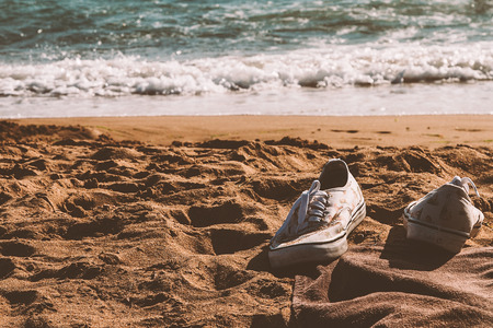 Sneakers left in a sandy beachの写真素材