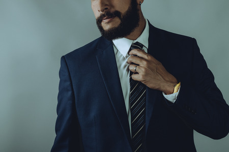 Beard man in a blue suit smirks
