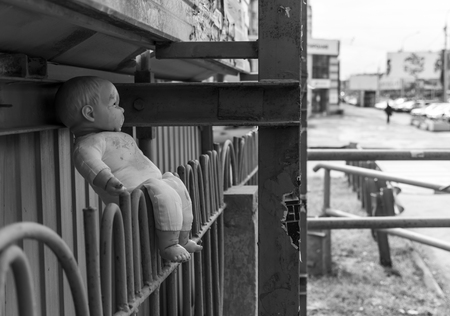 Abandoned doll left on the fenceの写真素材