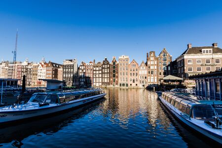Cruise boats moored on the Damrak canal of Amsterdamの写真素材