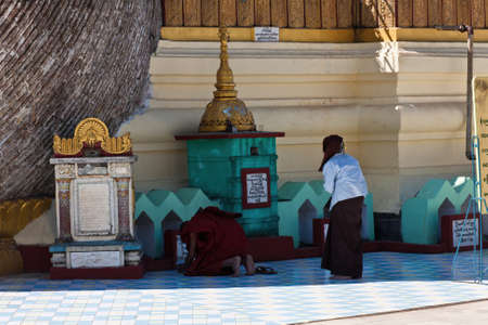 Praying people at the Old Hti of the Shwemawdaw Pagoda, Bago, Myanmar
