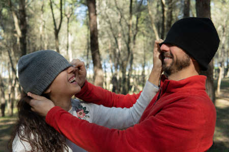 Young woman and young man playing and laughing in the wood