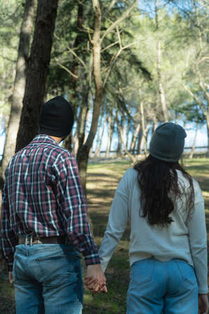 Back of a young couple during a trekking day in the wood