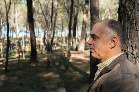 Mature man thinking and relaxing in the forestの写真素材