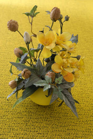Artificial flowers ona table in yellow flower-pot.の写真素材