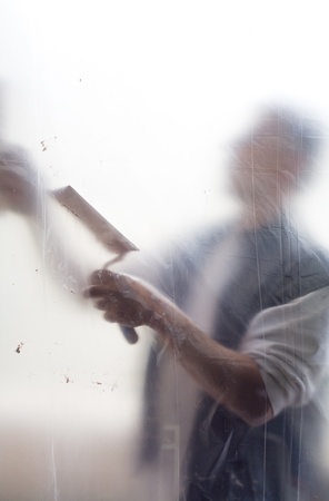craftsman, plasterer, working behind a protective foil