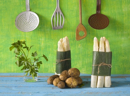 fresh asparagus, potatoes, parsley and vintage kitchen utensilsの写真素材