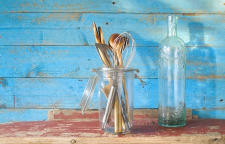 vintage kitchen utensils, wooden spoons and an old ornamented bottleの写真素材