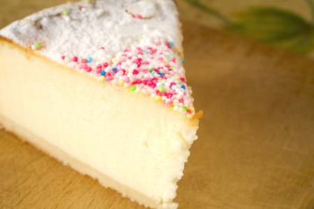 slice of cheese cake with hundreds and thousands decorationの写真素材