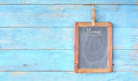 old black board for menu, free copy space, with rustic wooden backgroundの写真素材