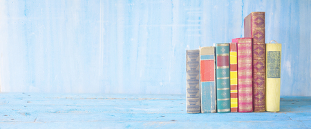 row of books on blue grungy background, panoramic, good copy spaceの写真素材