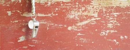 whistle of a soccer / football referee or trainer, grungy background, free copy spaceの写真素材