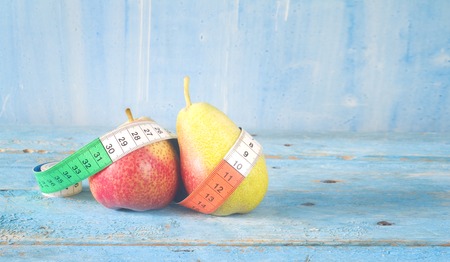 dieting concept with fresh pears and measuring tape, good copy spaceの写真素材