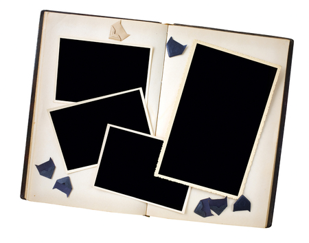 empty old photo frames in a book with photo corners, isolated on white, free copy spaceの写真素材