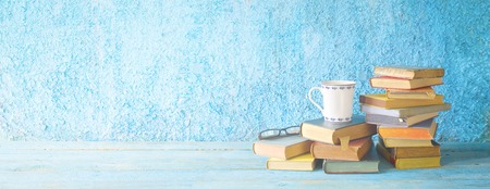 Pile of old books,glasses and a cup of coffee. Reading, literature,education concept. Panoramic with free copy spaceの写真素材