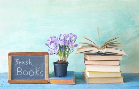 Open book and a blackboard advertising the new books of the new seasonの写真素材