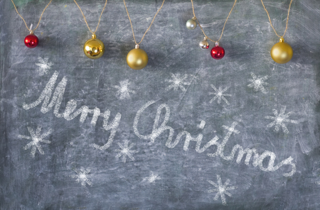 Christmas decoration on chalkboard, with lettering and Christmas tree ballsの写真素材