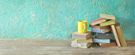 Pile of old books and a cup of coffee, panorama, reading education,literature concept good copy spaceの写真素材