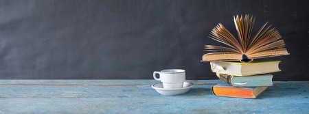 open book on a stack of books and a cup of coffee. Reading, learning, education, literature, panorama, good copy spaceの写真素材