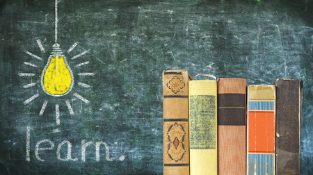 Learning concept, row of books, chalk drawing lightbulb on blackboard, free copy spaceの写真素材