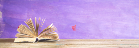 open book on purple grungy background, reading, education, literature,panorama, good copy spaceの写真素材