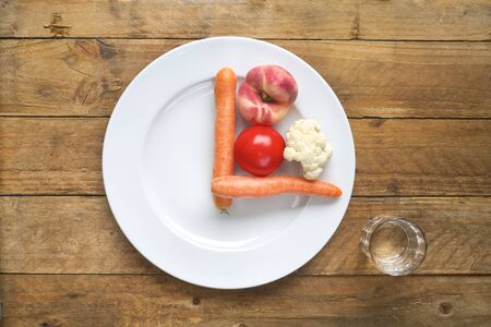 Intermittend fastening, dieting, healthy food concept. Plate with clock face, vegetables,glass of waterの写真素材