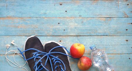 Fitness, sport, workout, running, concept with pair of runners, water, apple headphones. Free copy space, flat lay.の写真素材