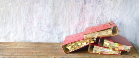 Heap of messy, old dusty file folders and documents, red tape, bureaucracy concept, panoramic, good copy space.の写真素材