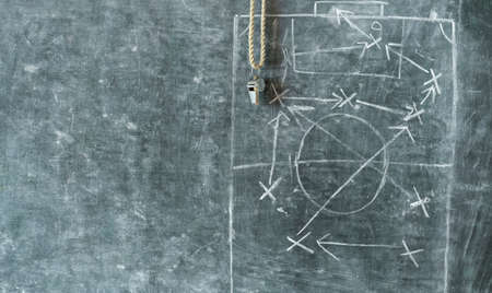 whistle of a soccer or football referee on black board with tactical diagram, free copy spaceの写真素材