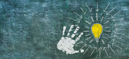 Idea, innovation, solutuion concept weth light bulb and human hand on black board, design template, large copy spaceの写真素材