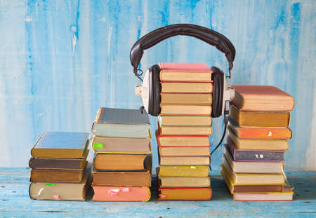 audio book concept with stacks of books and vintage headphones, good copy spaceの写真素材
