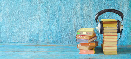 audio book concept with large heaps of books and vintage headphones, copy spaceの写真素材